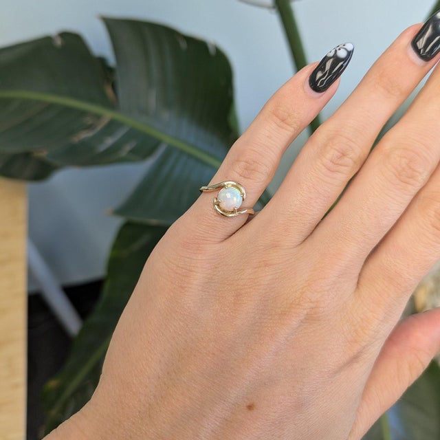 A 1-carat Ethiopian opal cabochon flashes with a full play of colour across this solid 14K yellow gold ring. Welo opals...