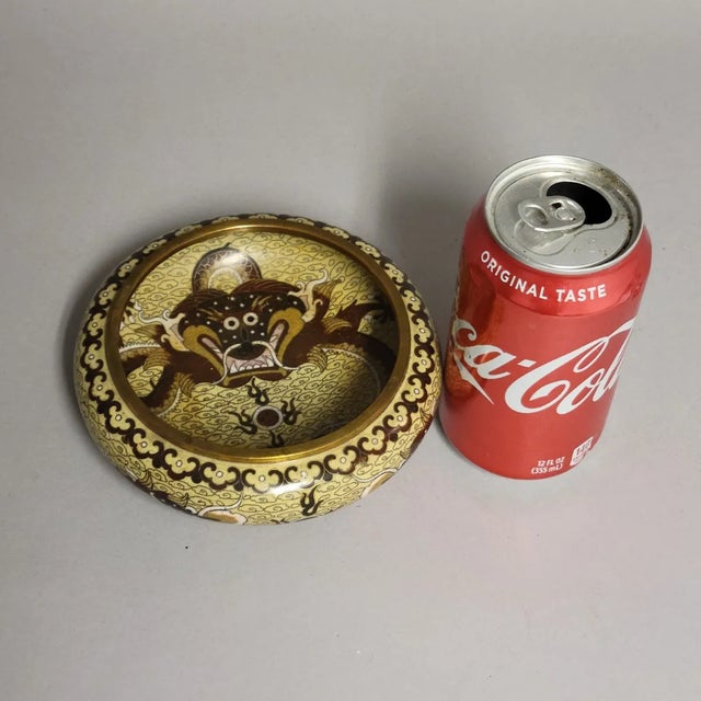 A captivating antique Chinese cloisonné bowl featuring a richly detailed five‑clawed dragon encircling a flaming pearl,...