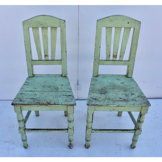 This is an attractive pair of painted pine plank seat chairs. The arched top rail encloses three broad splats. The two...
