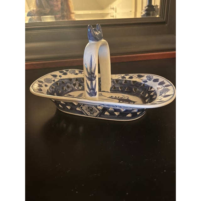 Beautiful ceramic blue and white handled basket with intricate details and cut outs.