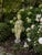 An evocative early-20th-century garden statue depicting a classically draped female figure in the Greco-Roman tradition....