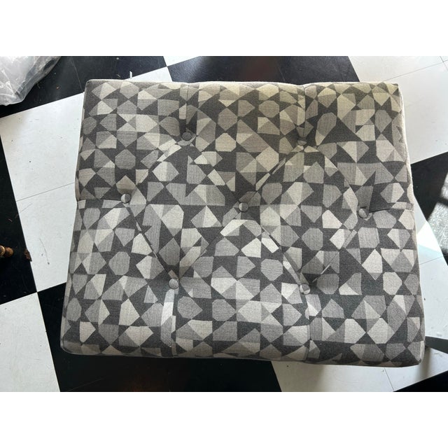 An ottoman newly upholstered with a Holland and Sherry geometric woven wool.