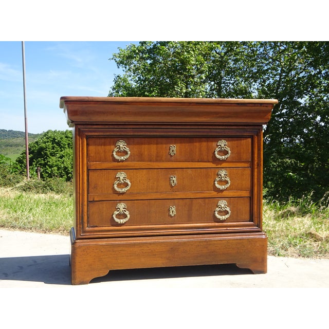 Beautiful chest of drawers in a honey-gold color, with four drawers, one of which is curved. Gilt bronze handles and...