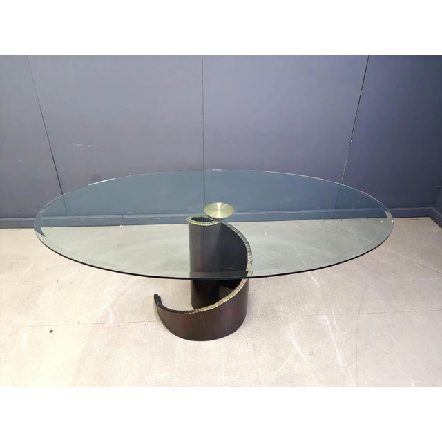 A hard-to-find Brutalist-style tempered, beveled, and smoked glass top and bronze base dining table by Maurice Barilone...