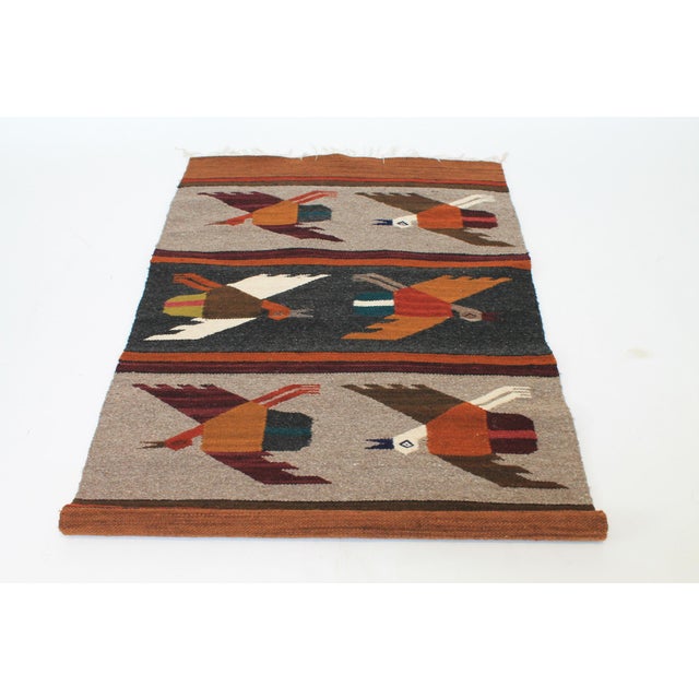 Vintage hand-woven wool wall hanging or tapestry featuring a geometric bird-in-flight motif. Features earth tone stylized...