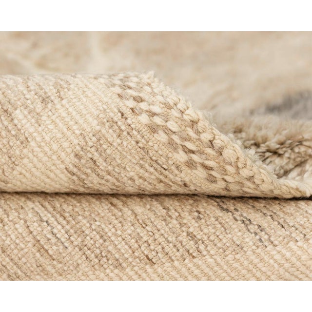 Exquisite, hand-knotted wool rug featuring a hand-woven Ivory abstract pattern, set against a gradient from Misty Taupe to...