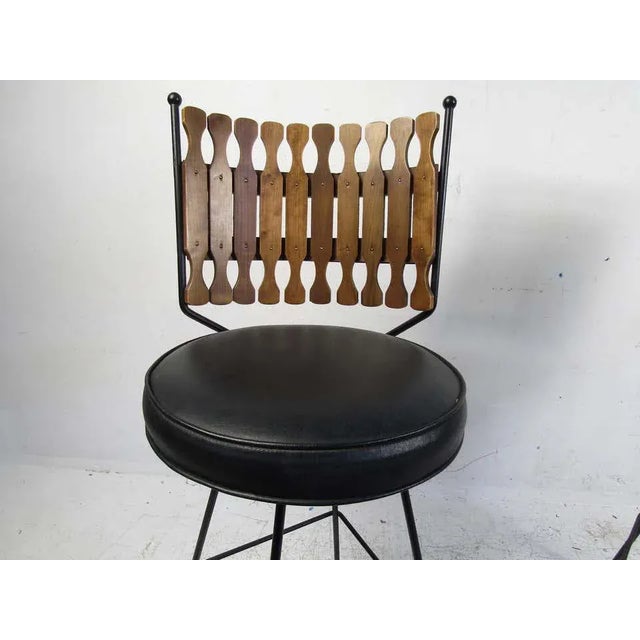 Interesting pair of vintage stools - iron frames, faux-leather upholstery, and carved wooden slats for a backrest. WEAR...