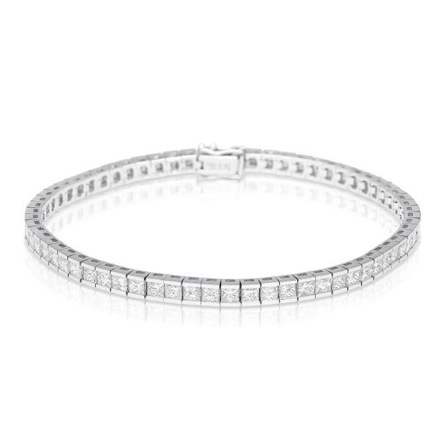Diamond Half Bezel Channel Set Tennis Bracelet. This unisex tennis bracelet features an array of 80 princess-cut white...