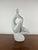 An elegant modernist ceramic sculpture depicting a stylized female figure in a meditative pose, made in Italy in the...