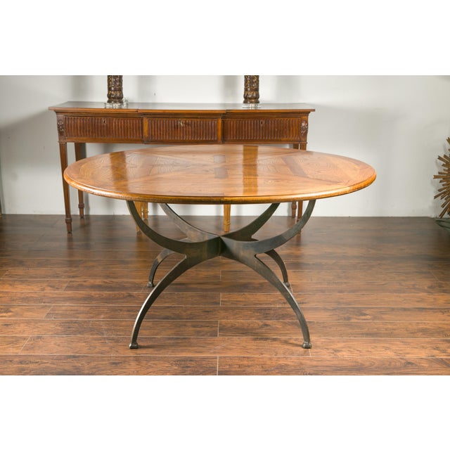 A French dining table with round parquetry top from the early 20th century and new custom iron base. Capturing our...