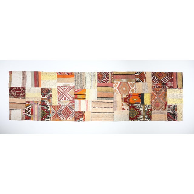This striking patchwork kilim is a one of a kind composition crafted from handwoven vintage fragments of tribal Turkish...