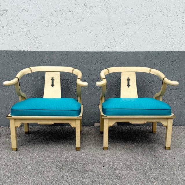 A striking pair of vintage Ming-style horseshoe lounge chairs featuring elegantly curved armrests and a classic Asian-...
