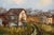 Original mid-century landscape painting on stretched canvas depicting a quiet rural scene with barns set among tall grass...