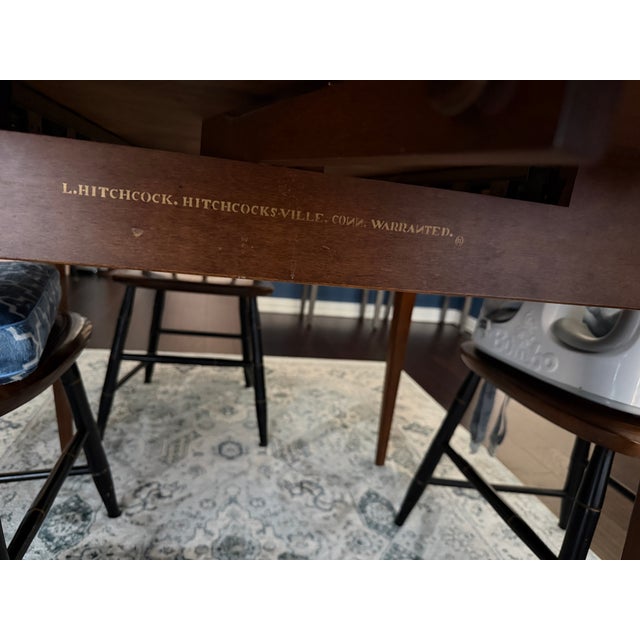 Vintage L Hitchcock cloverleaf drop leaf table with harvest finish. Has two additional leaves. Comes with eight chairs....