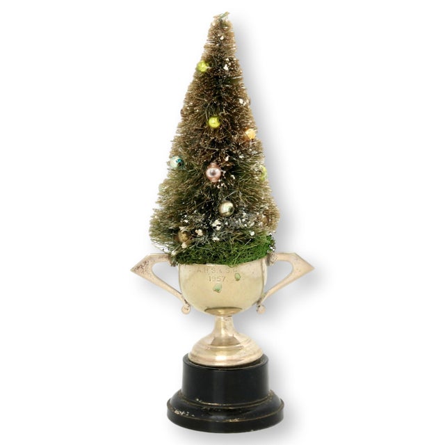 Bottle brush Christmas tree with small pastel ornaments in 1957 metal trophy.