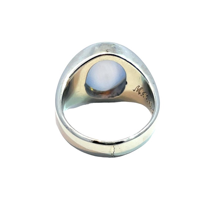 Elegant 14k white gold ring featuring an oval star sapphire accented by two small diamonds on each side. This substantial...