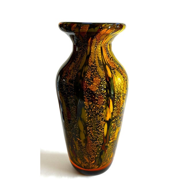 This brown glass vase with streaks of earth tone colors of olive green , rust, black and ochre streaks over gold dust...