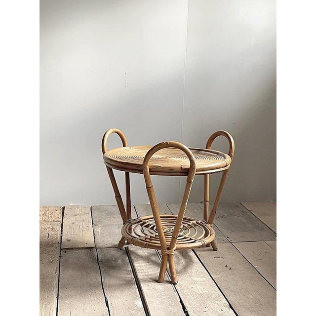 A distinctive handcrafted rattan side table made in Japan, most likely during the 1970s. The design is defined by three...