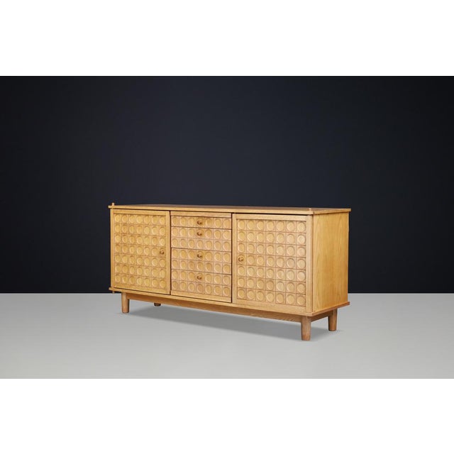 A striking Belgian Brutalist sideboard crafted in oak during the 1970s, featuring an exceptional façade of deeply carved...