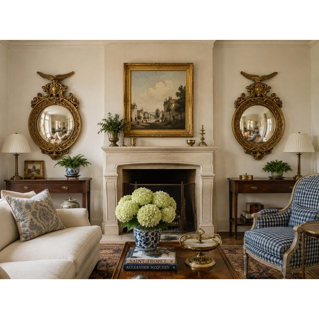 A rare matched pair of large Federal-style convex mirrors, each crowned by a finely modeled spread-wing eagle above an...