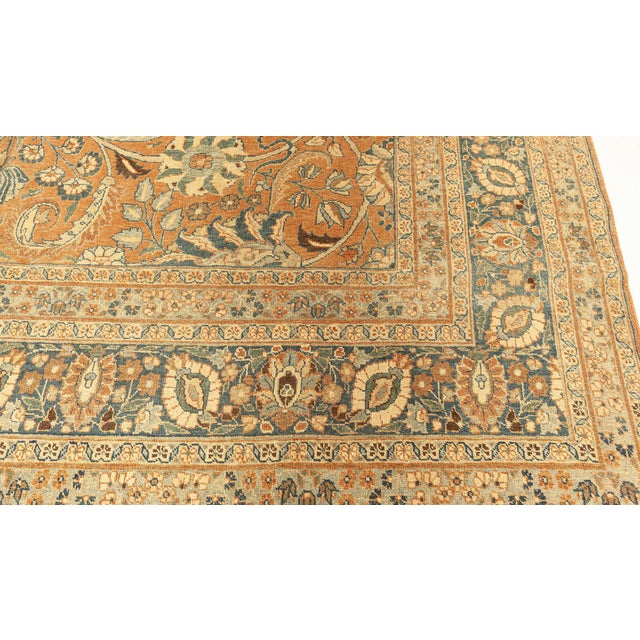 An early 20th century Persian Tabriz antique rug, the rust field with a playful allover trellis of swirling arabesques,...