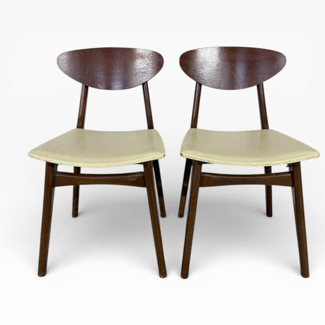 A stylish pair of mid-century Danish dining chairs featuring elegant butterfly-shaped backs and softly curved silhouettes....