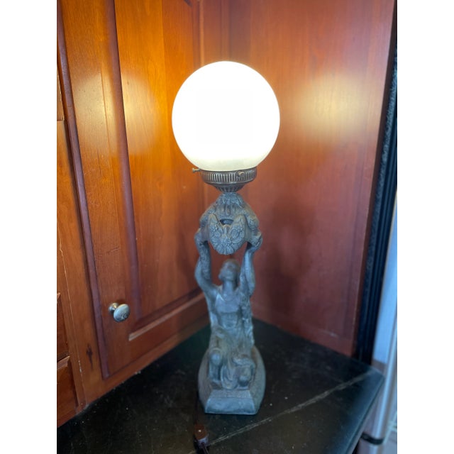 An unusual Art Deco table lamp by La Belle Specialty Company made in the 1920's. This figural lamp depicts a kneeling Joan...