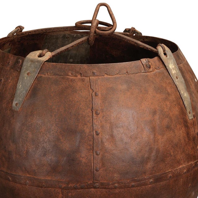 A striking mid-20th century iron water bucket from Rajasthan, hand-forged from shaped iron sheets and secured with...