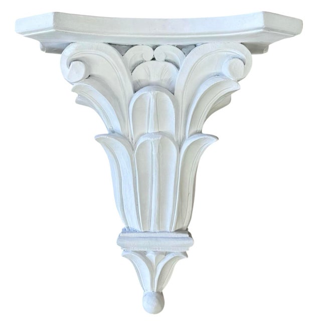 A pair of large wall brackets of cast plaster; each having a concave shelf supported by heavily moulded stylized acanthus...