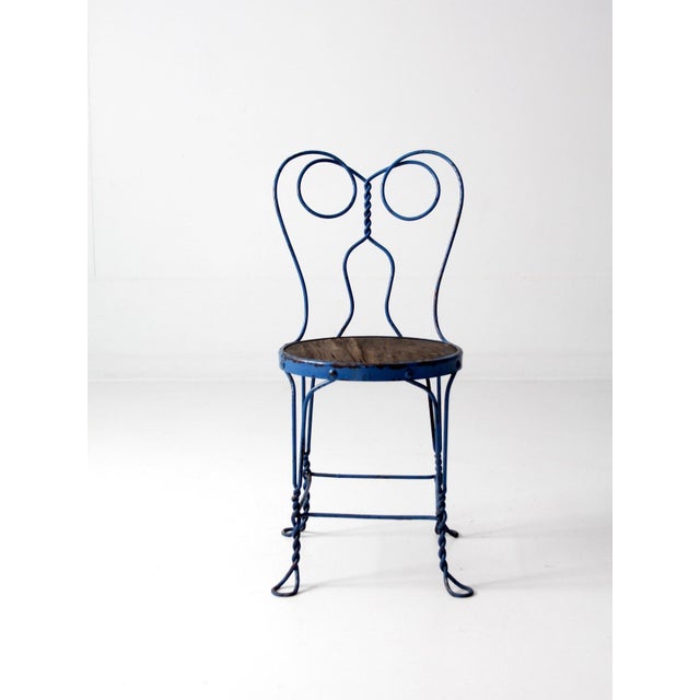This vintage ice cream parlor chair dates to the early 20th century and features a classic spectacle-back design formed in...