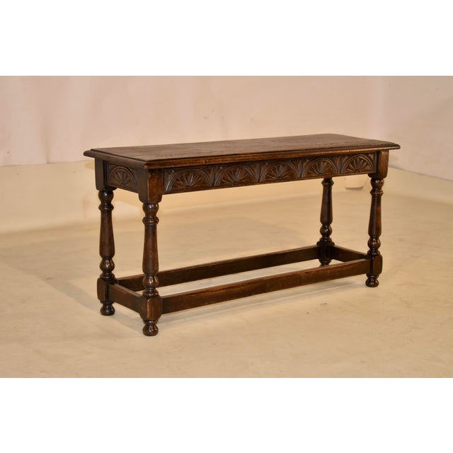 Circa 1900 oak bench from England. The top is nicely grained and has a beveled edge. The top follows down to a hand carved...