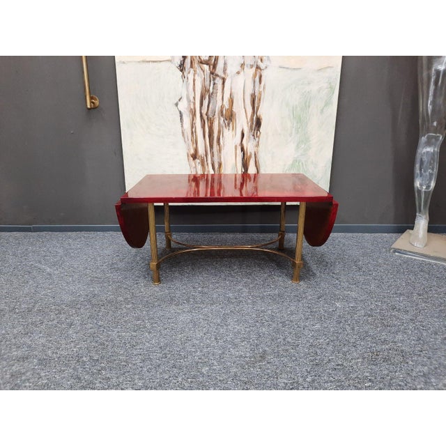 A very rare fold-out coffee table by Aldo Tura. Made in the 1950s or 60s. Red. The original label is located under the...