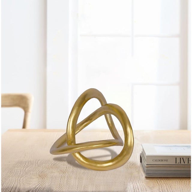 Add a touch of modern sophistication with this gold geometric knot sculpture, inspired by the elegance of the Möbius...