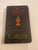 This compact Catholic missal features a black pebbled cover with red and gold lettering and traditional Eucharistic...