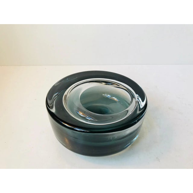 This is a cast and hand-thrown Holmegaard glass dish in an unusual shape. Suitable for nuts, jewellery or as an ashtray....