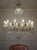 Large Empire-style chandelier in gilded iron with gold leaf, glass, and cut crystal, made in Italy in the 1940s. The...