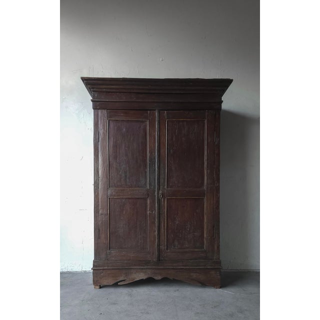 This is a 19th Century, rustic European two-door armoire crafted from solid wood, featuring a beautifully aged, timeworn...