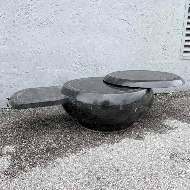 Extends to 47” when swiveled open. Pull out leaf is 15”d, 19.25”w. This postmodern coffee table pairs dramatic black...