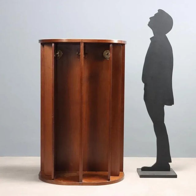 Wooden hall tree with white glass top, rotating elements and metal parts. This piece is attributed to the mentioned...