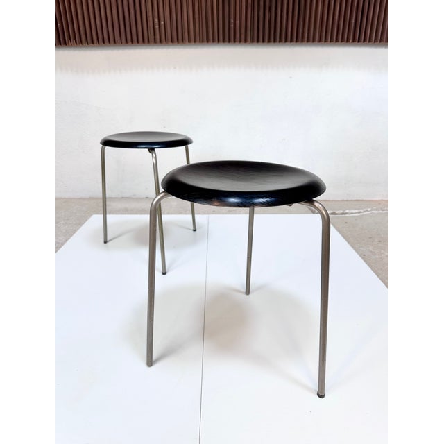Iconic pair of stools, model 3170 by Arne Jacobsen for Fritz Hansen from the 1960s, with three metal legs and a black-...