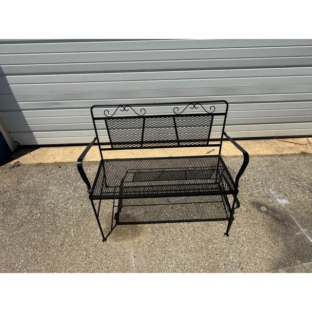 Classic vintage wrought iron garden bench featuring an elegant scrollwork crest rail and expanded metal mesh seat and...