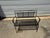 Classic vintage wrought iron garden bench featuring an elegant scrollwork crest rail and expanded metal mesh seat and...
