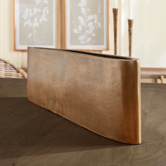 With an unexpectedly long and narrow shape, this abstract metal vase is made for the contemporary space. Wellscaled, with...