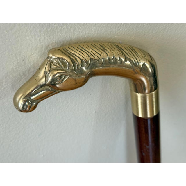 Handsome, Chinoiserie figural horse head walking cane in solid brass with wooden shaft. Disassembles into three pieces....