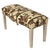 A charming upholstered bench with a curved seat covered in a warm-toned floral textile featuring a structured, repeating...