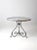A charming antique metal garden table in a softly weathered blue-gray finish. The round tabletop is supported by...