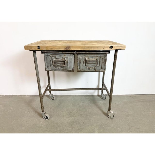 Vintage Industrial worktable from the 1960s. It features an iron construction with four original wheels, a solid wooden...
