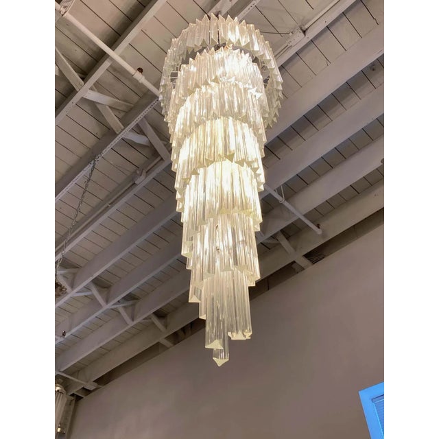 Stunning Mid-Century Modern Italian spiral chandelier. Each of the prisms are solid glass. They hang from hooks onto a...