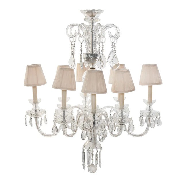 Elegant Georgian-style cut glass chandelier featuring eight lights arranged on gracefully scrolled arms. This refined...