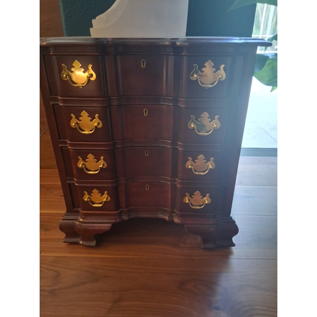 An exceptional mid-20th-century Georgian and Chippendale style block-front bachelor’s chest of drawers, showcasing the...